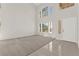 Open living space with neutral carpet, tile entryway, soaring ceilings, and an abundance of natural light at 8934 Pomona Ct, Las Vegas, NV 89147