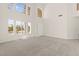 Bright living room with high ceilings, large windows, plush carpeting, and tiled entry for easy maintenance at 8934 Pomona Ct, Las Vegas, NV 89147