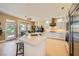 Bright kitchen with white cabinetry, large island, stainless steel appliances, and backyard views at 10013 Hunter Springs Dr, Las Vegas, NV 89134