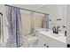 Bathroom featuring a large mirror, white vanity with black hardware, and a shower tub with a floral-patterned curtain at 10180 Delray Beach Ave # 202, Las Vegas, NV 89129