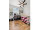 Well-lit bedroom with ceiling fan, organized craft supplies, work tables, and bright natural light from the window at 10180 Delray Beach Ave # 202, Las Vegas, NV 89129