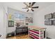 Cozy bedroom with ceiling fan, organized craft supplies, work tables, and bright natural light from the window at 10180 Delray Beach Ave # 202, Las Vegas, NV 89129