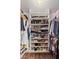 Walk-in closet with built-in shelving and storage for shoes, bags, and clothes, all decorated with floral wallpaper at 10180 Delray Beach Ave # 202, Las Vegas, NV 89129