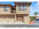 Three-story condo building features garages, a balcony, and neutral-toned stucco, offering comfort and style at 10180 Delray Beach Ave # 202, Las Vegas, NV 89129