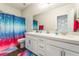 Bright bathroom with dual sinks, white cabinetry, tub/shower combo and vibrant shower curtain at 10829 Crestview Pointe Ave, Las Vegas, NV 89166