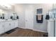 Well lit bathroom featuring a double sink vanity, framed mirrors, and wood look floors at 10829 Crestview Pointe Ave, Las Vegas, NV 89166