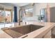 Bright kitchen features a large island with a sink and a stainless steel refrigerator at 10829 Crestview Pointe Ave, Las Vegas, NV 89166