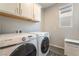 Convenient laundry room area featuring modern appliances, storage, and a window at 10829 Crestview Pointe Ave, Las Vegas, NV 89166
