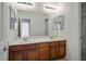 Bathroom featuring double sinks with mirrors and wooden cabinets at 11569 Velicata Ct, Las Vegas, NV 89138