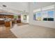 Open concept living room adjacent to the kitchen, featuring large windows and recessed lighting at 11569 Velicata Ct, Las Vegas, NV 89138
