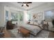 Staged bedroom with large bed, sitting area, and lots of natural light at 11569 Velicata Ct, Las Vegas, NV 89138