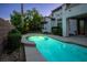 Backyard swimming pool with waterfall feature surrounded by lush landscaping at dusk at 11569 Velicata Ct, Las Vegas, NV 89138