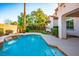 Backyard swimming pool with waterfall feature surrounded by lush landscaping at 11569 Velicata Ct, Las Vegas, NV 89138