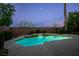 Backyard swimming pool with waterfall feature surrounded by lush landscaping at dusk at 11569 Velicata Ct, Las Vegas, NV 89138