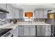 Modern kitchen with stainless steel appliances, light gray cabinets, and stylish tile backsplash at 1589 Silver Mesa Way, Las Vegas, NV 89169