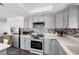 Modern kitchen with stainless steel appliances, light gray cabinets, and stylish tile backsplash at 1589 Silver Mesa Way, Las Vegas, NV 89169