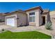 Front exterior featuring desert landscaping, two-car garage, and neutral stucco at 177 Shaded Peak St, Henderson, NV 89012