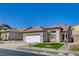 Tan single-story home with desert landscaping, attached two-car garage and concrete driveway at 177 Shaded Peak St, Henderson, NV 89012