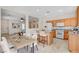 Bright, staged kitchen featuring wooden cabinets, stainless steel appliances and dining table at 177 Shaded Peak St, Henderson, NV 89012