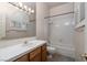 Bright bathroom featuring a shower over tub, toilet, vanity with sink and decorative shuttered window at 2104 Inverness Dr, Henderson, NV 89074