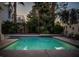 Stunning backyard at dusk featuring a shimmering pool, palm trees, and a charming home exterior at 2104 Inverness Dr, Henderson, NV 89074