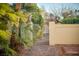 Foliage surrounds a yard and courtyard with a brick walkway and gate to the home at 2104 Inverness Dr, Henderson, NV 89074