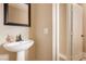 Cozy bathroom featuring a pedestal sink, framed mirror and a white paneled door at 2199 Timescape Ct, Las Vegas, NV 89123