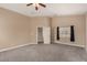 A carpeted bedroom with neutral colored walls, a ceiling fan, and window with black curtains at 2199 Timescape Ct, Las Vegas, NV 89123