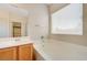 Bathroom featuring dual sinks, soaking tub, and a large mirror, creating a spa-like experience at 2445 Sturrock Dr, Henderson, NV 89044