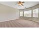 Spacious bedroom featuring plush carpet, ceiling fan, and natural light from multiple windows at 2445 Sturrock Dr, Henderson, NV 89044
