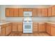 A bright kitchen with wooden cabinets, white appliances, and plenty of counter space at 2445 Sturrock Dr, Henderson, NV 89044