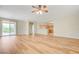 Bright living room with wood-look floors, fan, and an open concept view into the kitchen at 2445 Sturrock Dr, Henderson, NV 89044