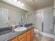 Bathroom with granite counters, wood cabinets, single sink, and glass enclosed shower at 2732 Dune Cove Rd, Las Vegas, NV 89117