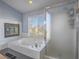 Bright bathroom featuring separate tub, shower, and window with blind at 2732 Dune Cove Rd, Las Vegas, NV 89117