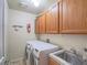 Well-lit laundry room includes a washer, dryer, sink, and ample cabinet space for storage at 2732 Dune Cove Rd, Las Vegas, NV 89117