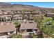Aerial view features home with tile roof, covered patio, and desert landscaping in a Primary-planned community at 2749 Liberation Dr, Henderson, NV 89044