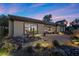 Beautiful back patio with rock landscaping, covered area with seating, and colorful sunset views in the sky at 2749 Liberation Dr, Henderson, NV 89044