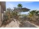 Inviting outdoor patio with table and seating amidst a well-manicured backyard and desert landscaping at 2749 Liberation Dr, Henderson, NV 89044