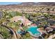 Aerial view of the community pool, hot tub, and clubhouse surrounded by palm trees and ample parking at 2749 Liberation Dr, Henderson, NV 89044