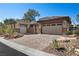 Charming single-story home featuring a three-car garage, desert landscaping, and a paved driveway at 2749 Liberation Dr, Henderson, NV 89044