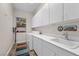 Bright laundry room featuring white cabinets, modern appliances, and a sink for added convenience at 2749 Liberation Dr, Henderson, NV 89044