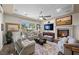 Cozy living room with a fireplace, ceiling fan, comfortable seating, and a large window at 2749 Liberation Dr, Henderson, NV 89044