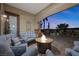 Inviting covered patio with comfortable seating, a fire pit, and views of palm trees at 2749 Liberation Dr, Henderson, NV 89044