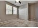 A cozy bedroom with neutral walls, carpeted floors, a ceiling fan, two windows, and a closet perfect for relaxation at 2915 Moulton Crest Ave, Henderson, NV 89044