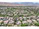 Eye-level aerial view showcasing tree lined roads, spacious homes, and majestic mountains in the background at 3000 Hammerwood Dr, Las Vegas, NV 89135
