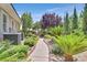 Landscaped backyard featuring a stone pathway, lush greenery, and vibrant plants for a serene outdoor setting at 3000 Hammerwood Dr, Las Vegas, NV 89135