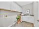 Practical laundry room with white cabinetry, granite countertops, and durable tile flooring, offering functionality and style at 3000 Hammerwood Dr, Las Vegas, NV 89135