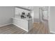 Modern kitchen featuring white cabinets, quartz countertops, stainless appliances, and wood-look flooring at 3236 Lahontan St, North Las Vegas, NV 89032