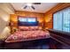 Log-walled bedroom with an ornate wooden bed frame and side tables featuring lamps at 401 Alpine Way, Las Vegas, NV 89124
