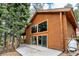 Log cabin with large windows and a deck, surrounded by tall trees and a forest-like setting at 401 Alpine Way, Las Vegas, NV 89124